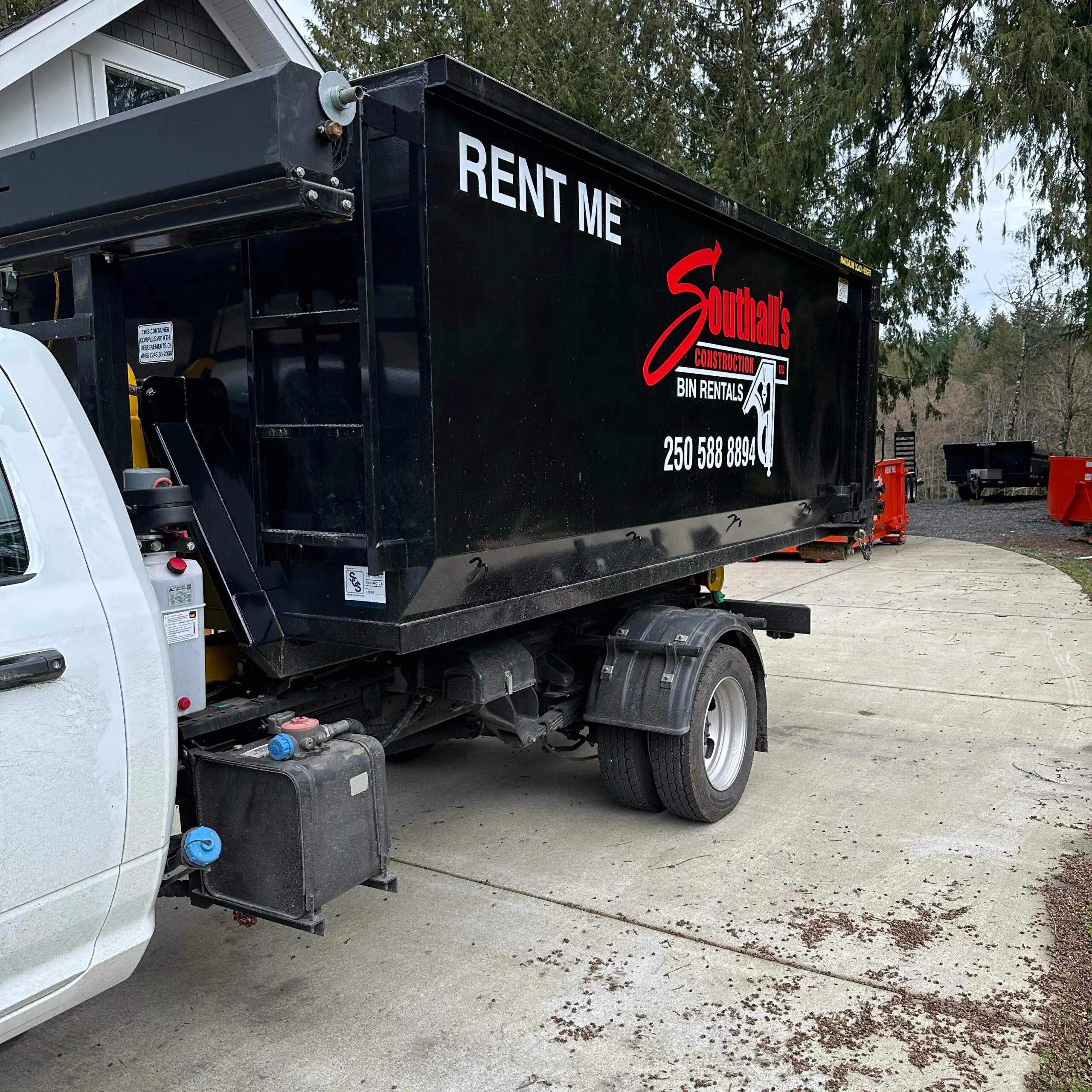 20 yard black construction bin being loaded onto Southall Services truck in Cowichan Valley