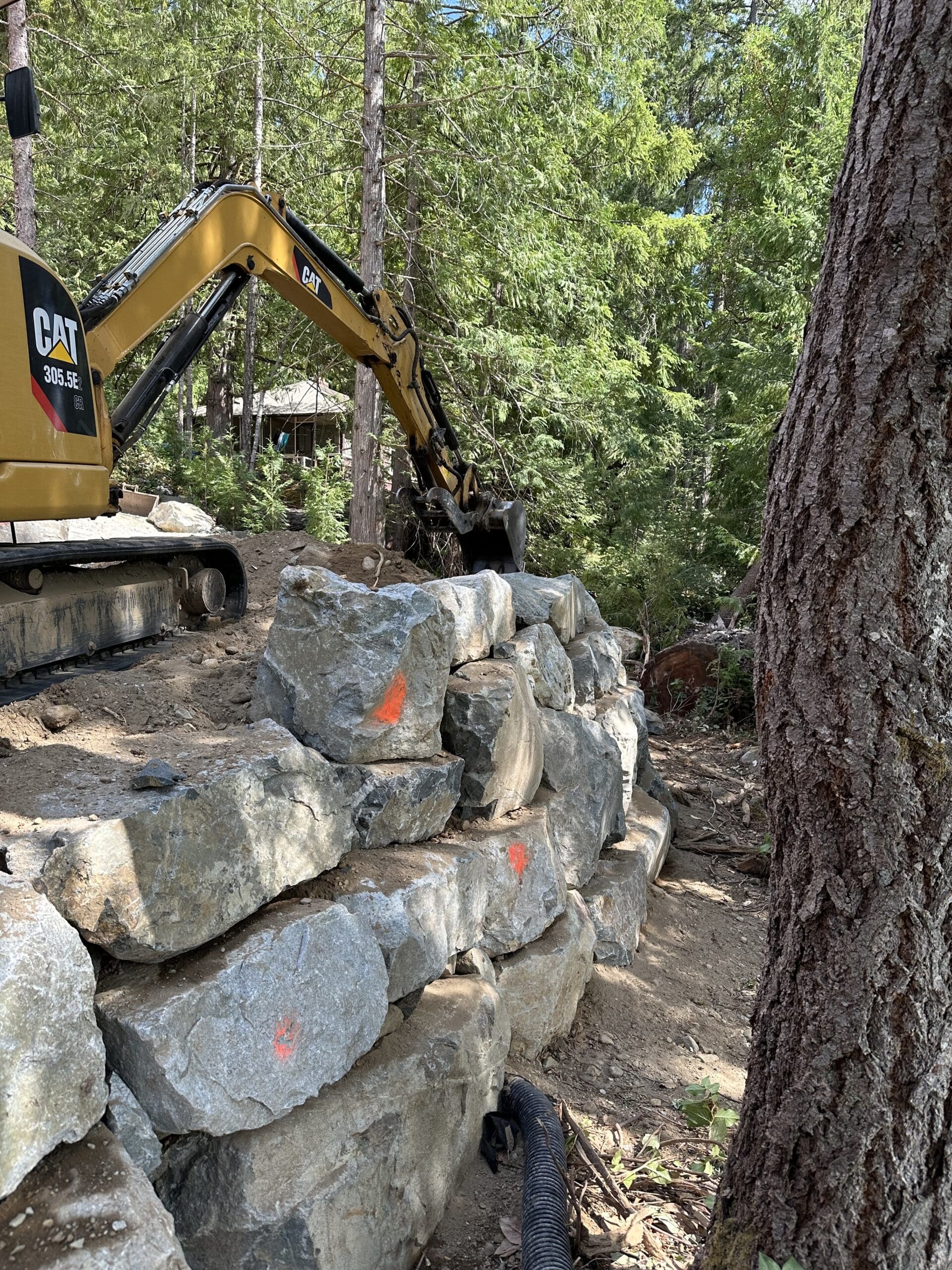 Rock retaining wall construction by Southall Services excavation crew