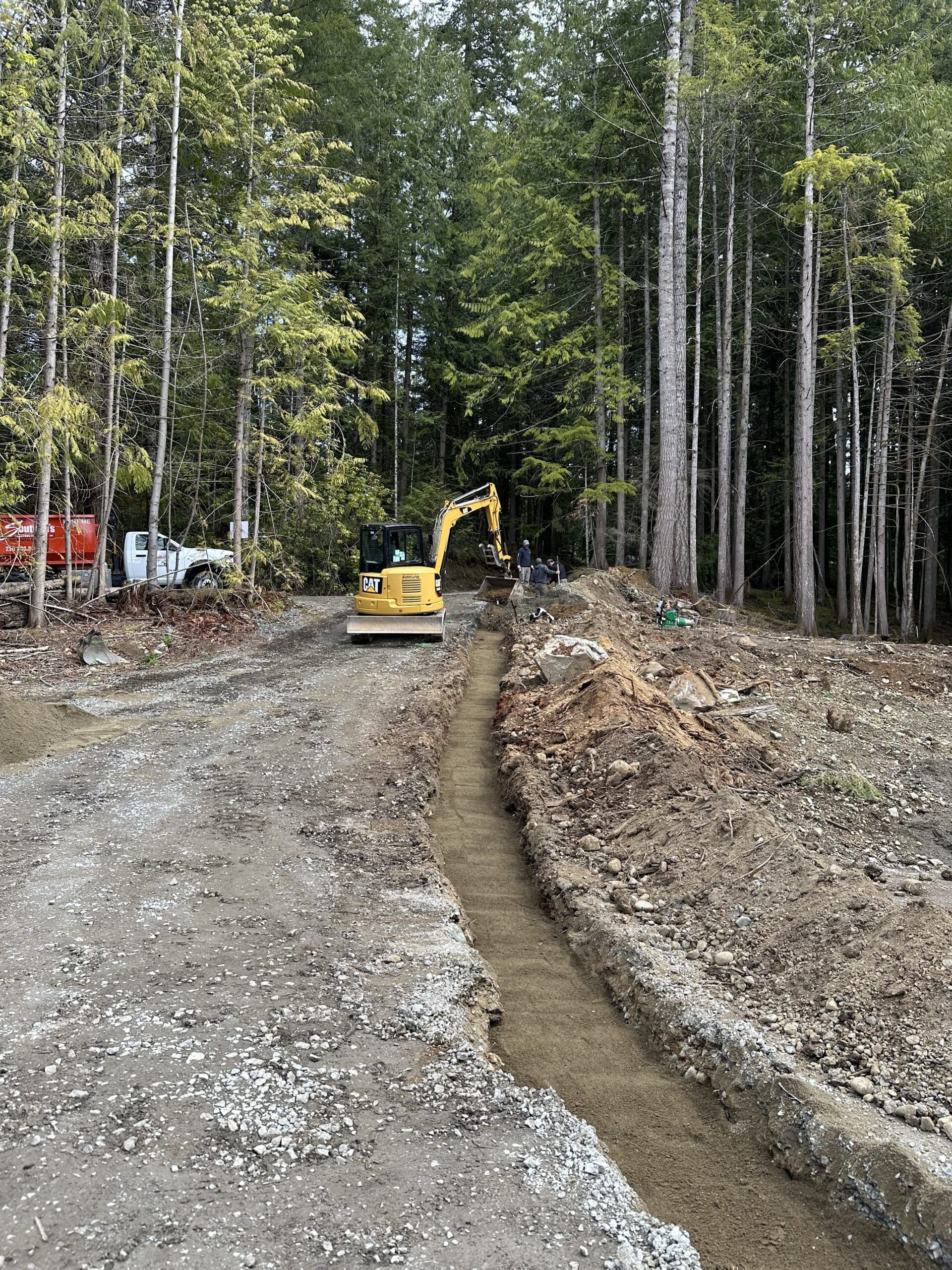 Excavation contractor digging drainage trench at Shawnigan Lake property in Cowichan Valley BC