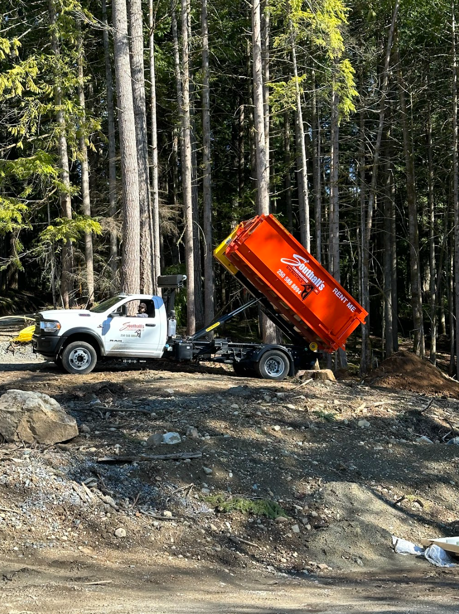Southall Services dump truck offloading a construction bin at a rural Cowichan Valley property