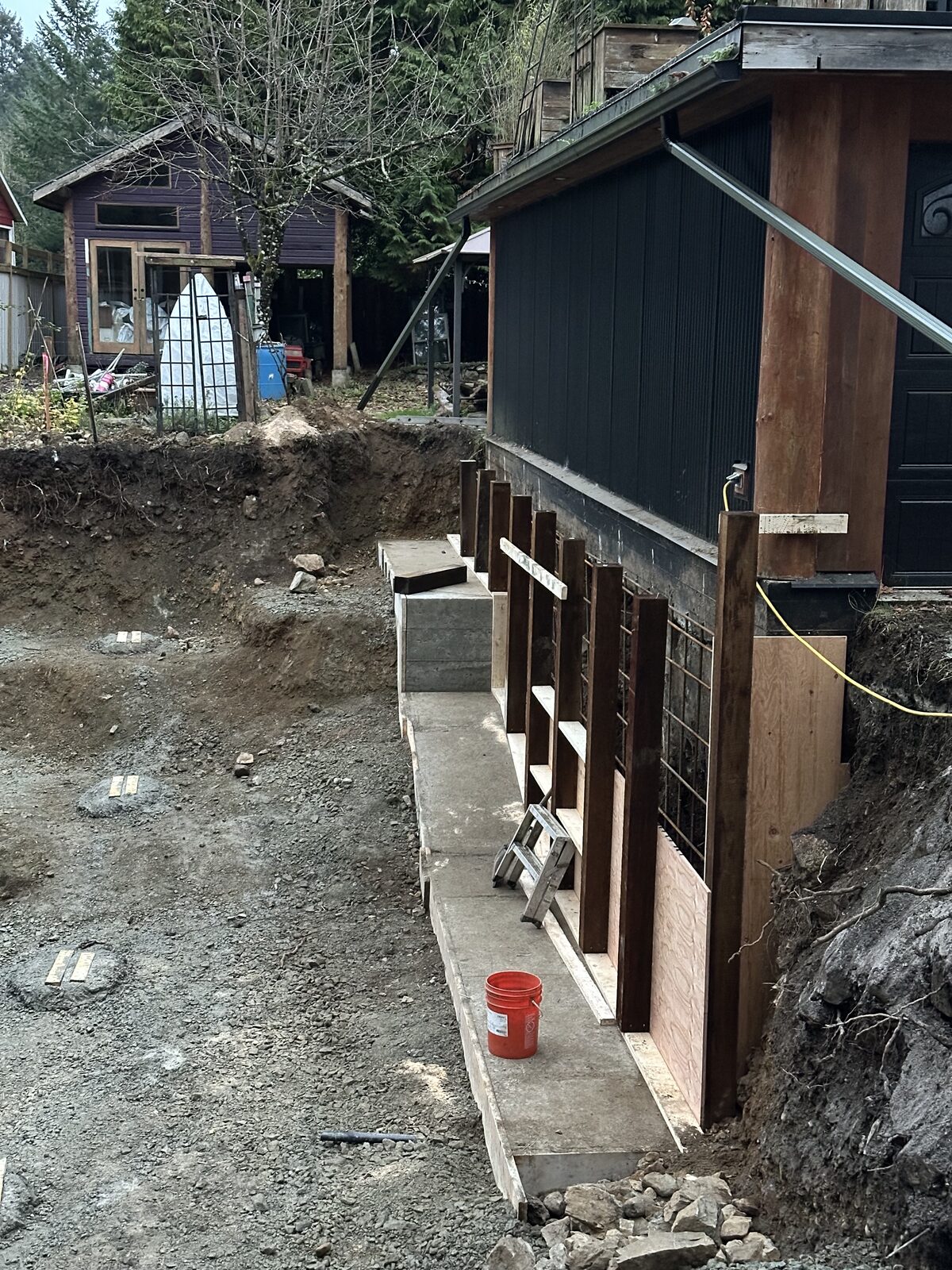 Foundation work along the existing house wall — garage addition and house underpinning project