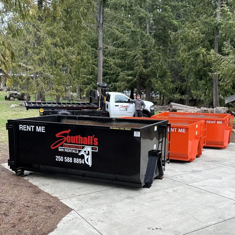 Southall’s Construction bin rental truck with multiple disposal bins parked on a residential driveway in the Cowichan Valley, showcasing a range of bin sizes available for local waste and renovation projects