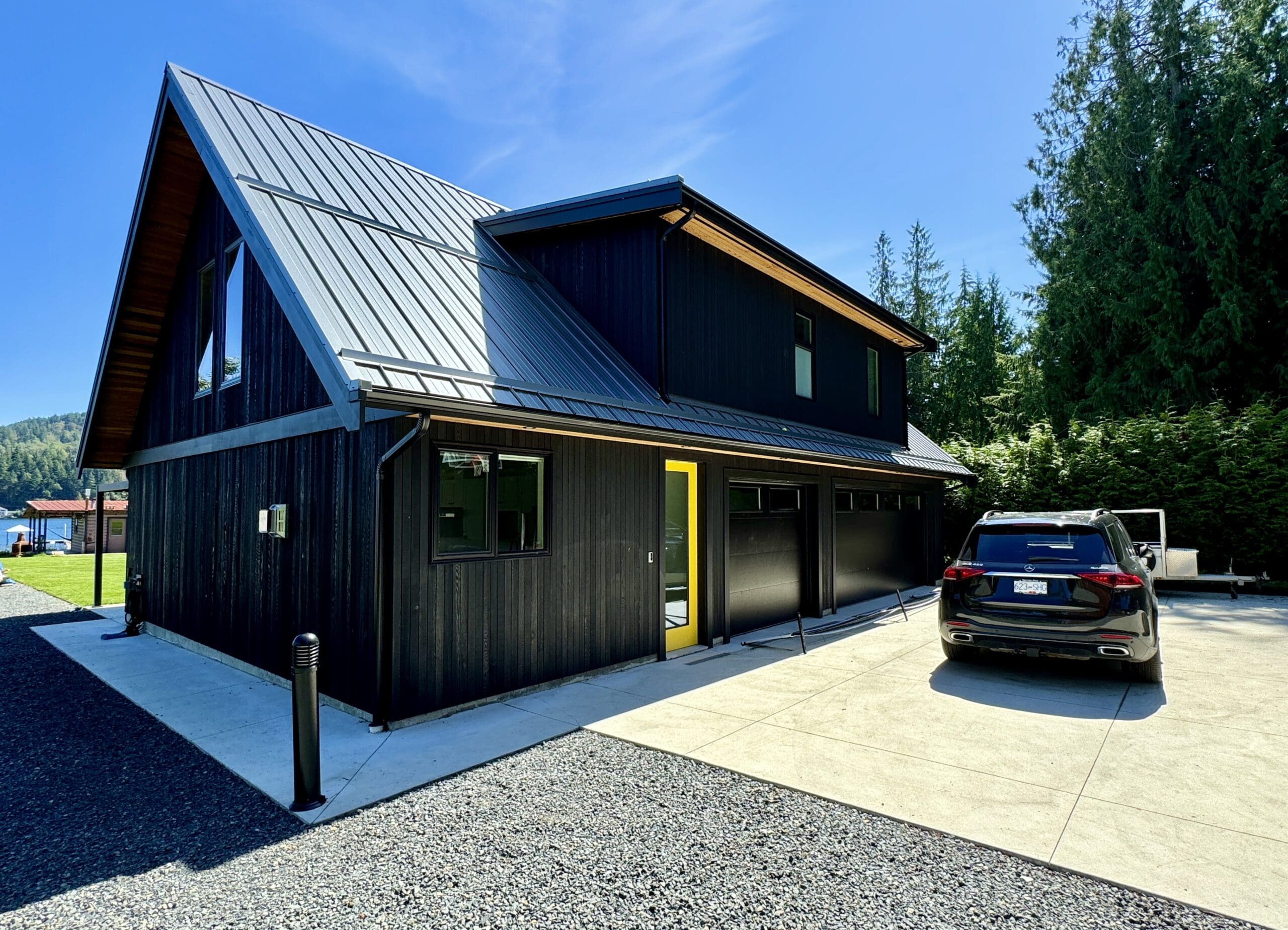 Modern black residential home with finished driveway and garage following site preparation and construction work in the Cowichan Valley, BC
